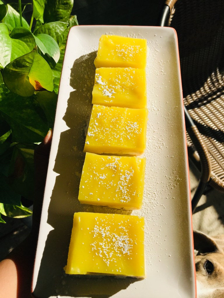 vegan lemon bar square with powdered sugar on a plate